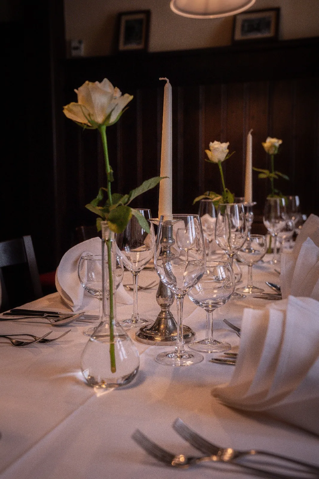 Festlich gedeckte Tafel mit Kerzenleuchtern und weißer Rose